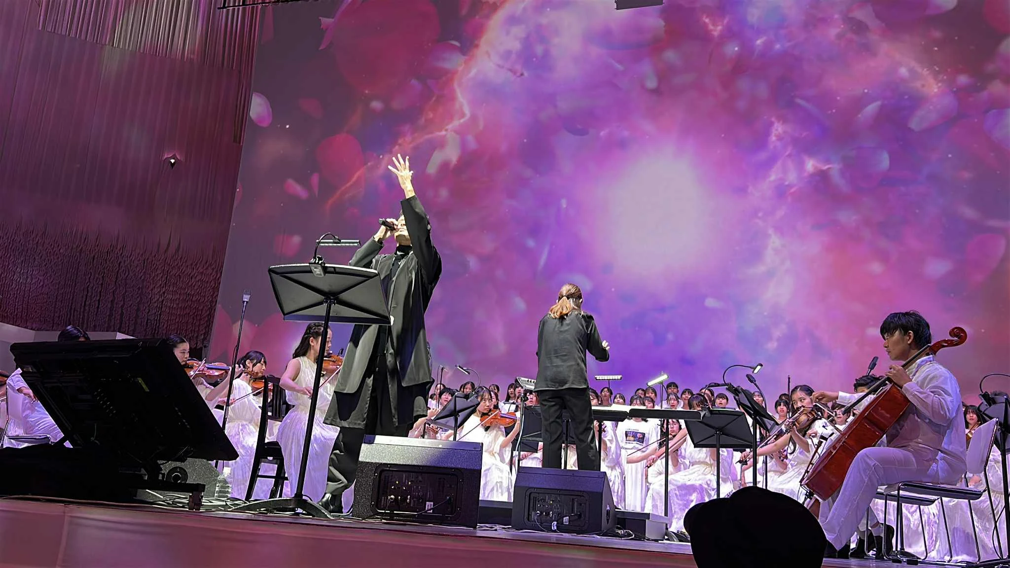 万博の公演で歌う橋本昌彦とスーパーキッズ・オーケストラ、合唱団